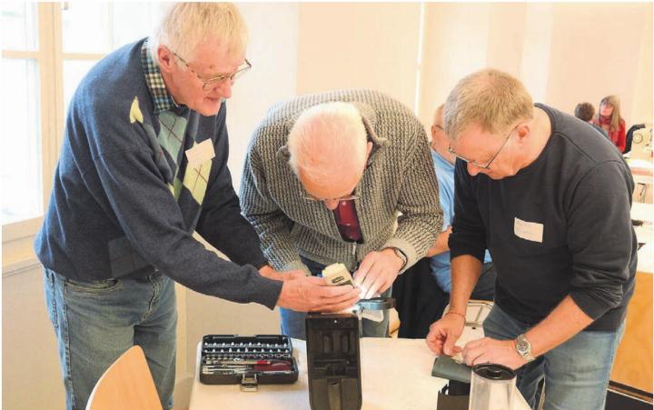 Gleich zu dritt kümmerte sich das Team um die defekte Kaffeemaschine. Dabei wird viel gefachsimpelt. Bilder: Chregi Hansen Gleich zu dritt kümmerte sich das Team um die defekte Kaffeemaschine. Dabei wird viel gefachsimpelt. Bilder: Chregi Hansen