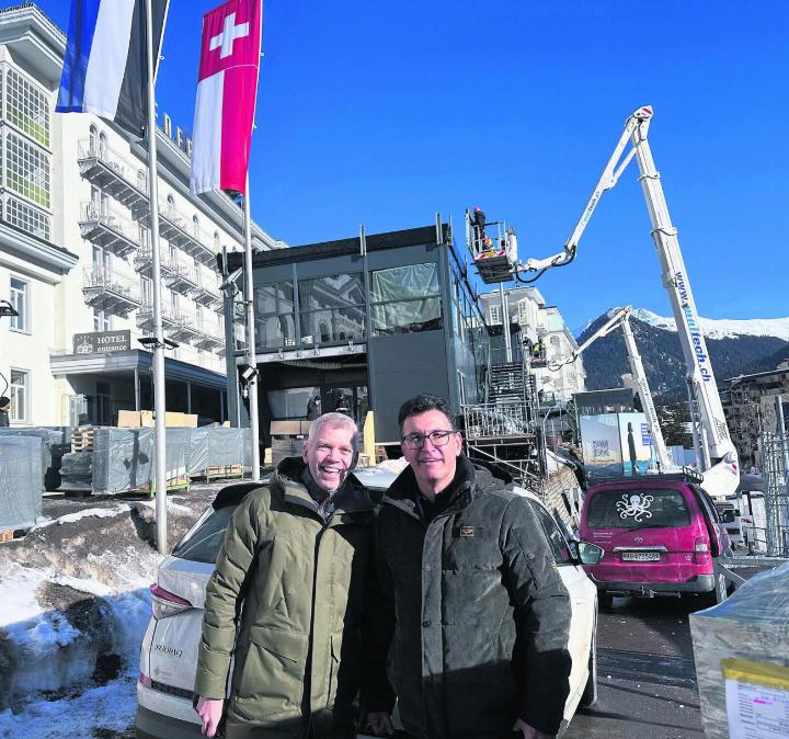 70 Sattelschlepper brachten 140 Tonnen Material zum Hotel Belvedere nach Davos. Der temporäre Bau der US-Firma «Dow Jones» im Hintergrund ist beeindruckend. Chris Mühlemann und André Richner von der Richnerstutz AG sind zufrieden. Bild: Stefan Sprenger