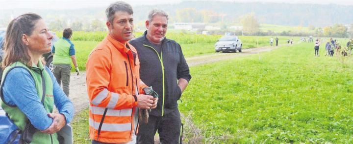 Während die Kinder auf dem Feld fleissig an der Arbeit sind, erklären Projektleiterin Inès Röthele von Pro Natura und die beiden Landwirte Mario Gebedinger und Lukas Vock (von links) die Hintergründe des Projekts auf ihrem Pachtland.