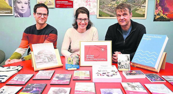 Die Hauptverantwortlichen von «Zeitgeschichte Aargau» präsentieren alle Erzeugnisse, samt dem kürzlich erhaltenen Award (v. l.): Fabian Furter, Ruth Wiederkehr und Patrick Zehnder. Bild: pd