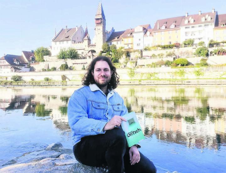Florian Oegerli mit seinem Roman an der Reuss vor der Bremgarter «Schoggiseite». «Manchmal vergesse ich, wie schön es hier ist, und bin von Neuem wieder regelrecht verzaubert», sagt er über das Städtli seiner Kindheit. Bild: Marco Huwyler