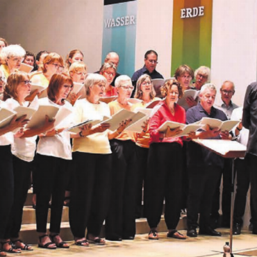 Full House bei gefühlten 40 Grad - Unter der Leitung von Roberto Vacca präsentiert der Chor ein vielseitiges Konzertprogramm, unterstützt von Lidiia Domanska am Flügel.
Bilder: Monica Rast
