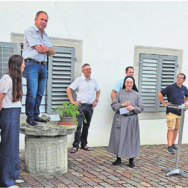 In Sorge um den elektrischen Strom - Präsident Markus Wey (auf Stein stehend) dankte Schwester Angelika vom Kloster Hermetschwil für die gewährte Gastfreundschaft beim Sommeranlass im kühlen Klostergarten.