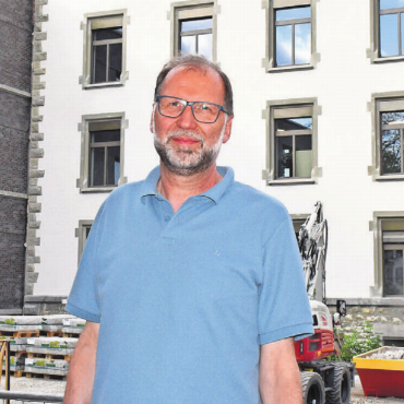 Basis für wertvolle Momente - Die grosse Erleichterung: Paul Bitschnau vor der neuen Bezirksschule, links der Anbau, rechts das renovierte und sanierte Gebäude.    Bild: Daniel Marti