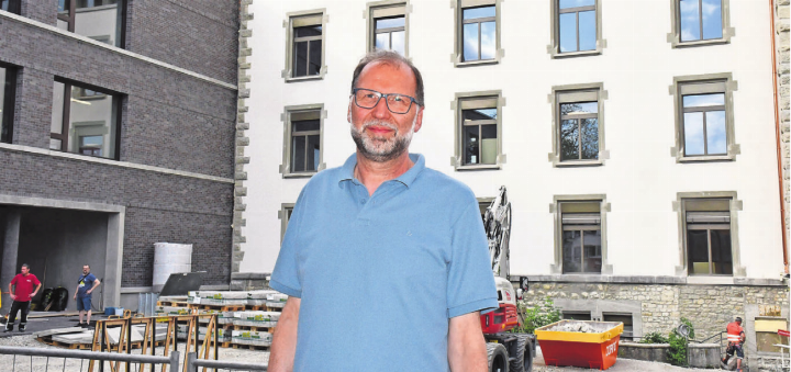 Die grosse Erleichterung: Paul Bitschnau vor der neuen Bezirksschule, links der Anbau, rechts das renovierte und sanierte Gebäude.    Bild: Daniel Marti