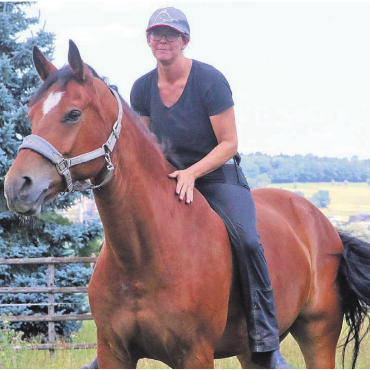 Zwischen Parkplatz und Parcours - Cornelia Wanderon auf Leroy. «An der Springkonkurrenz in Wohlen werde ich aber voraussichtlich unsere Stute Valentina reiten und mein Partner ihn», sagt sie.    Bilder: Josip Lasic/zg